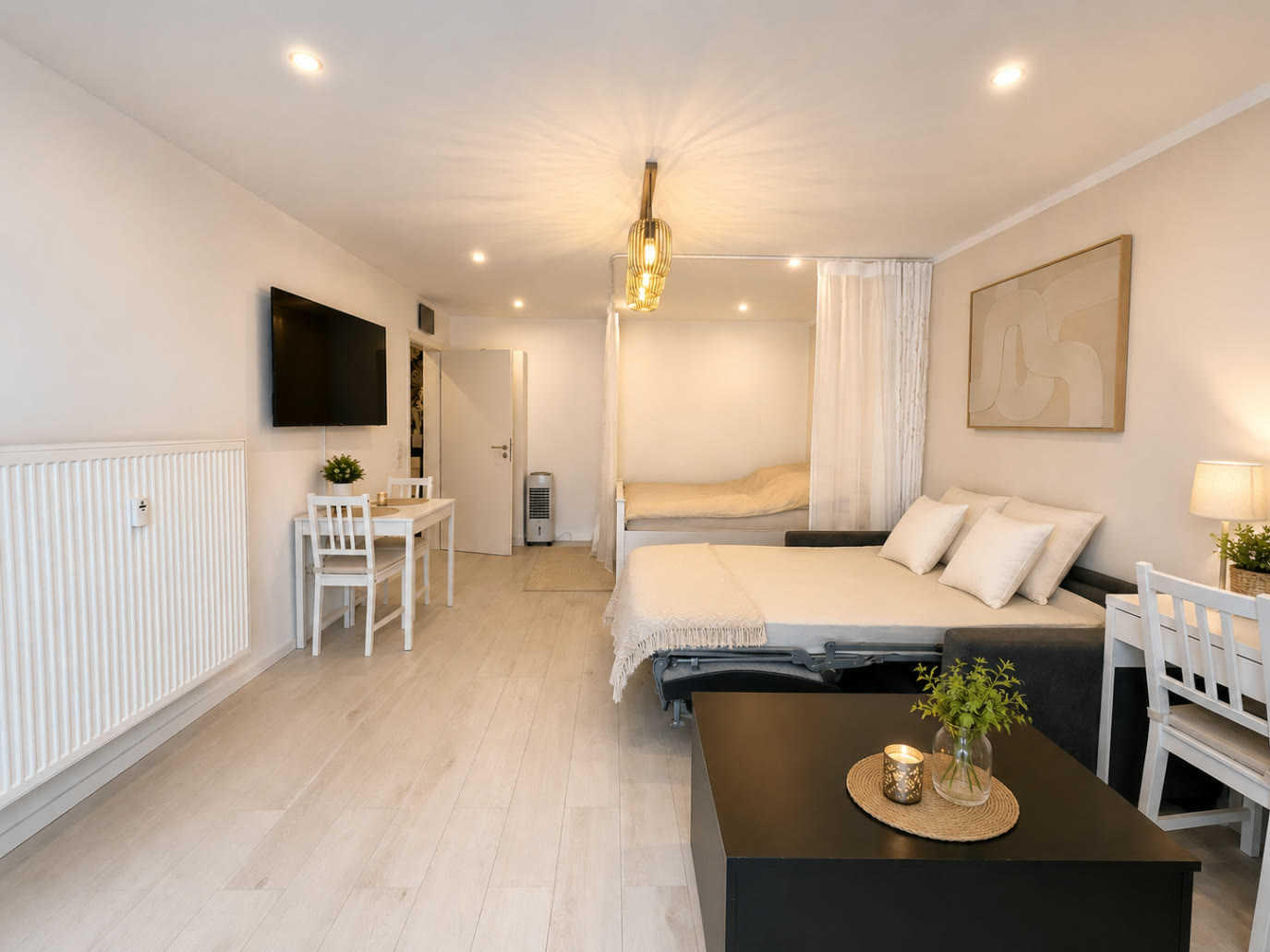 Ausgezogenes Schlafsofa im Wohnbereich des Apartments